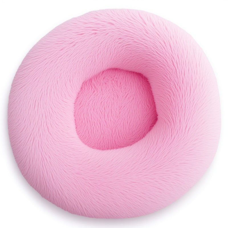 Bright pink round calming bed for dogs and cats, fluffy plush design perfect for cuddly naps.