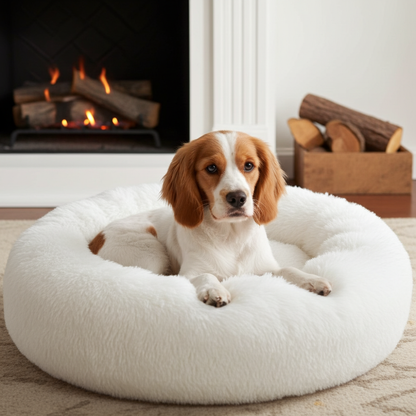 Dog lying on a fluffy white pet bed in front of a fireplace.