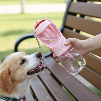 Dog drinking from a pink pet water bottle held by a person on a wooden bench outdoors.
