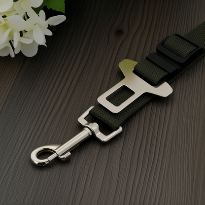 Black dog leash with silver clip on a wooden surface with white flowers.