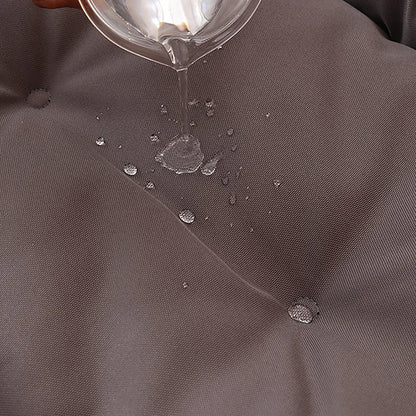 Close-up of grey 600D Oxford waterproof dog bed fabric with water being poured onto the surface.