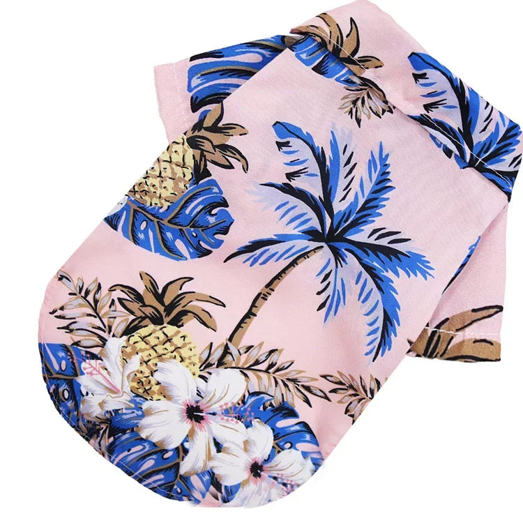 Folded pink fabric with tropical leaf and pineapple pattern on a white background