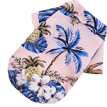 Folded pink fabric with tropical leaf and pineapple pattern on a white background