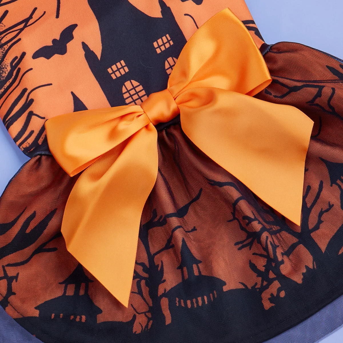 Halloween-themed fabric with orange bow, pumpkins, and ghosts on an orange background.