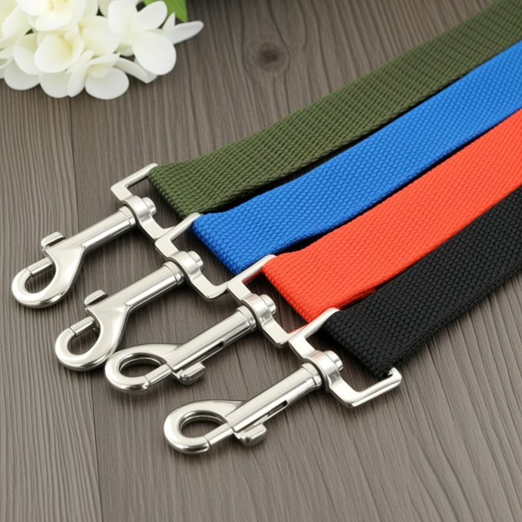 Four dog leashes in green, blue, red, and black with metal clasps on a wooden surface.