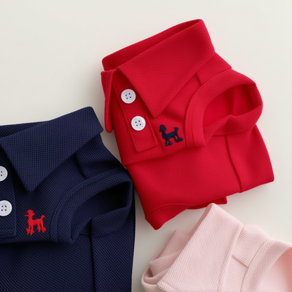 Red, navy, and pink polo shirts with a dog logo on a light background