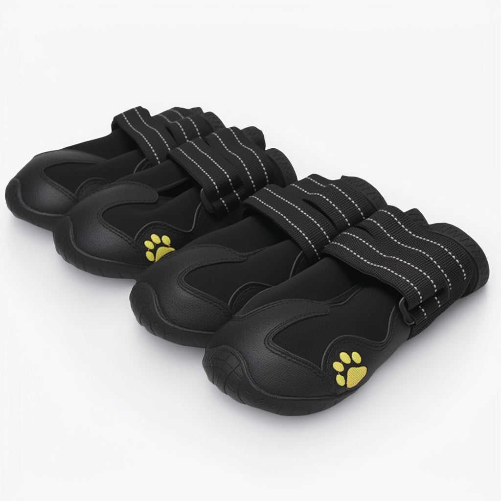Set of black pet shoes with yellow paw prints on a white background