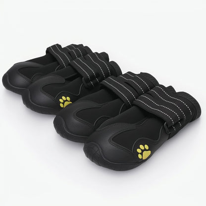 Set of black pet shoes with yellow paw prints on a white background