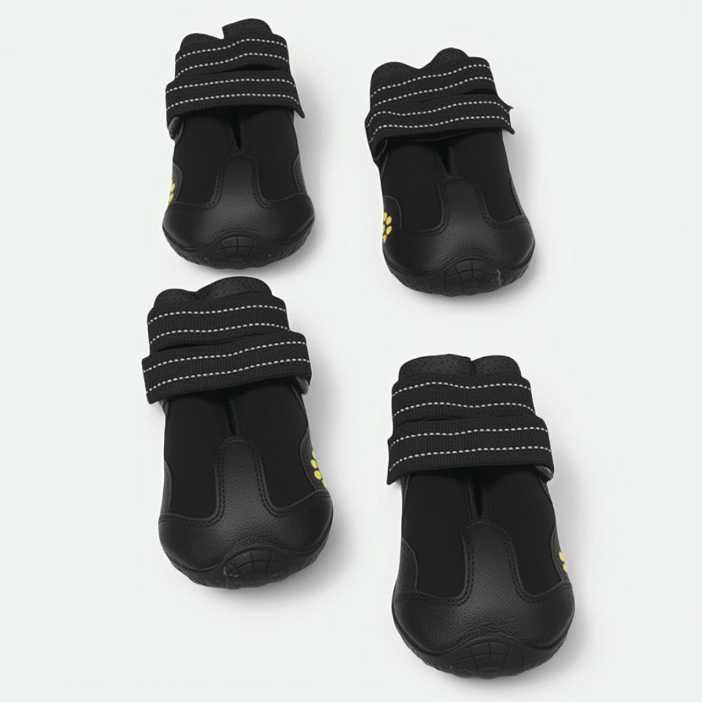 Four black dog boots with straps on a white background