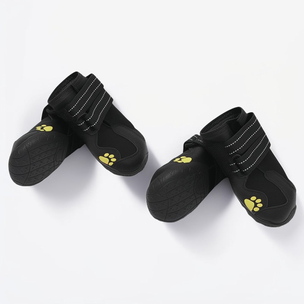 Pair of black pet boots with yellow paw prints on a white background